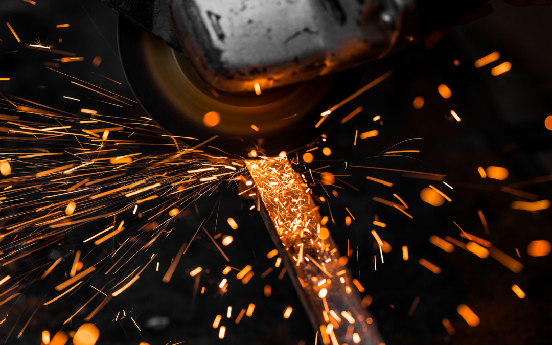 Close-up of aluminium fabrication work with sparks flying from a grinding machine during metal cutting